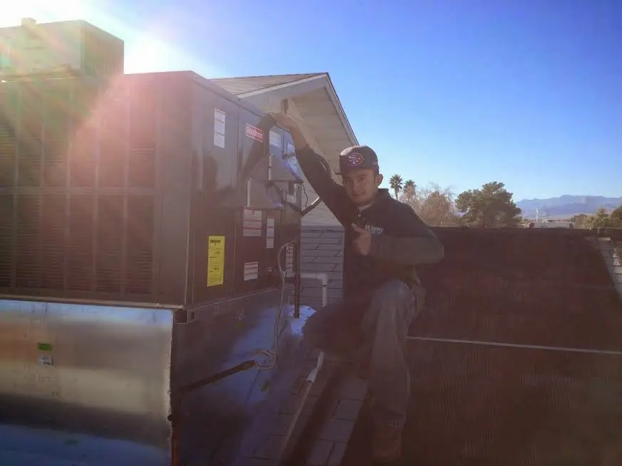 HVAC technician performing Heat Pump Repair on a rooftop unit in Attalla